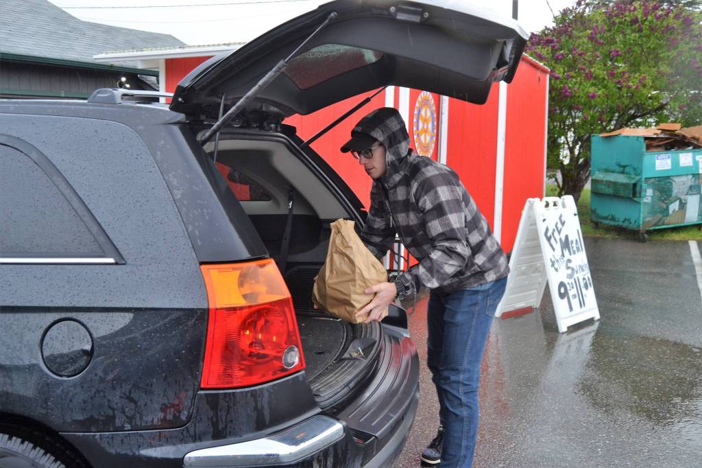 Grant Pierson, a Sequim High graduate and Westpoint student, helps load a vehicle with food. He volunteered at the Sequim Food Bank on May 2 while hes home from school. Sequim Gazette photo by Matthew Nash