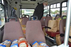 Larry Grant, a maintenance worker and driver for Suncrest Village Retirement Community, helps load the bus for residents who signed up for items from the Sequim Food Bank. Grant said they sign up and he returns to pick up their food every two weeks. Sequim Gazette photo by Matthew Nash