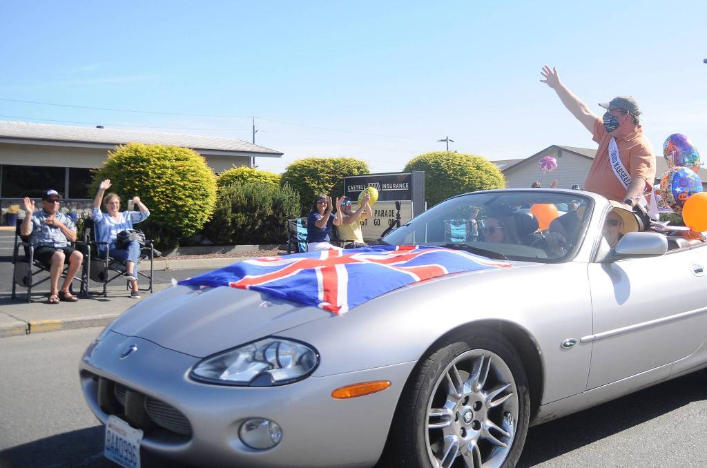 Phil Castell, the 2020 Irrigation Festival Grand Parade marshal, waves to a small gathering on what would have been the festivals parade day on May 9. With the festival postponed until October, Castell hosted the small, one-car parade to mark the original day of the Grand Parade. Sequim Gazette photo by Michael Dashiell