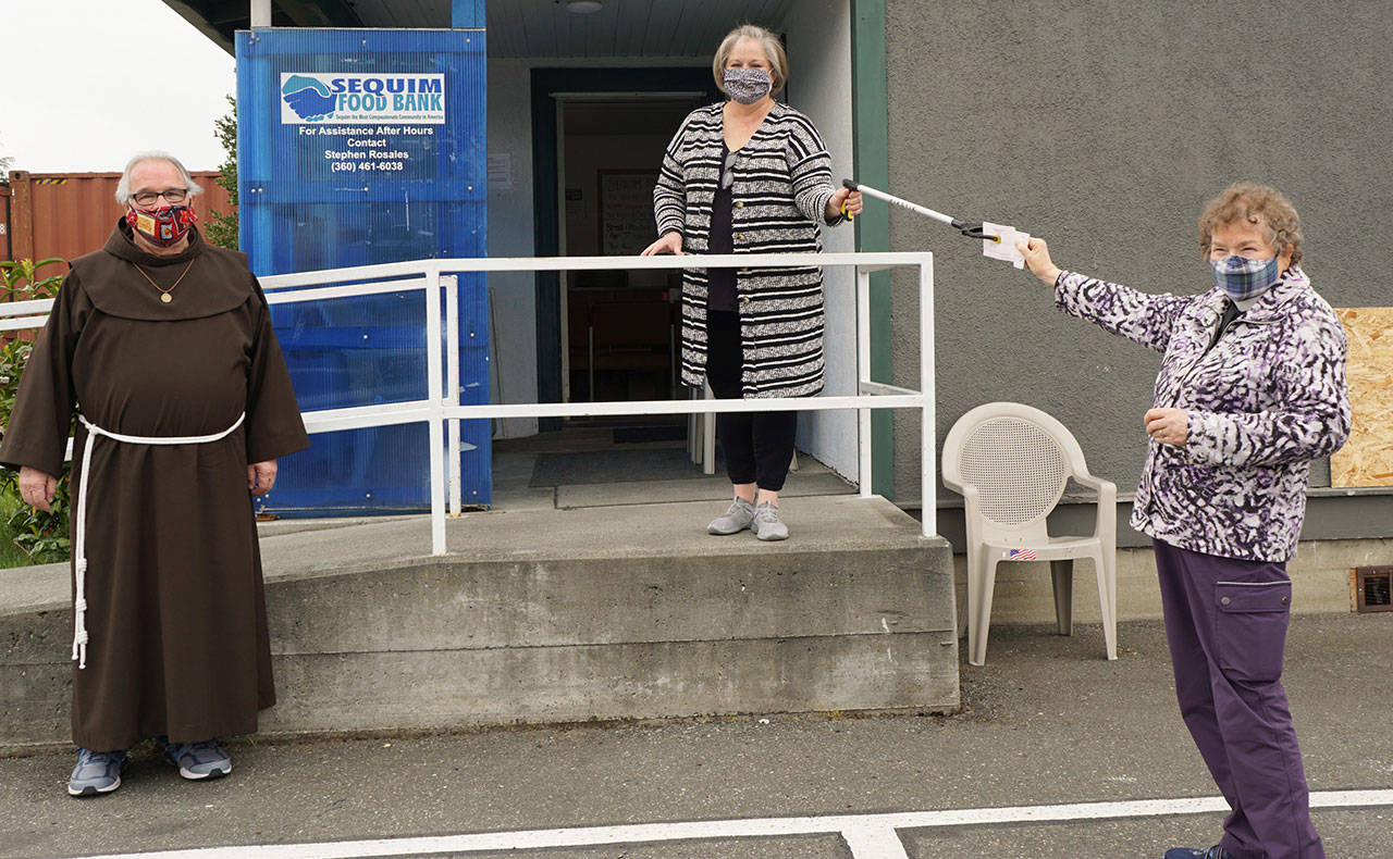 Andrea Smith (center), Executive Director of the Sequim Food Bank, accepts a donation from St. Lukes Episcopal Church, represented here by Steve Penning and Rev. Dianne Moore. Submitted photo