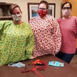 Nurses at Avamere Olympic Rehabilitation of Sequim, from left, Lynda Lyons, CNA; A.J. Henning, CNA; and Jo Talbot, RN; show masks and gowns made by members of Sunbonnet Sue Quilt Club. In total, club members made more than 4,500 face masks for community health workers. Photo courtesy of Avamere/Sunbonnet Sue Quilt Club