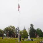 Deidre Magner, longtime groundskeeper for Sequim View Cemetery, raises the flag at the cemetery on Memorial Day just before noon. Flags at local cemeteries were lowered to half mast through mid-day Monday in recognition of the holiday. Local veterans groups cancelled Memorial Day ceremonies with a statewide ban on large gatherings in place. Sequim Gazette photos by Michael Dashiell