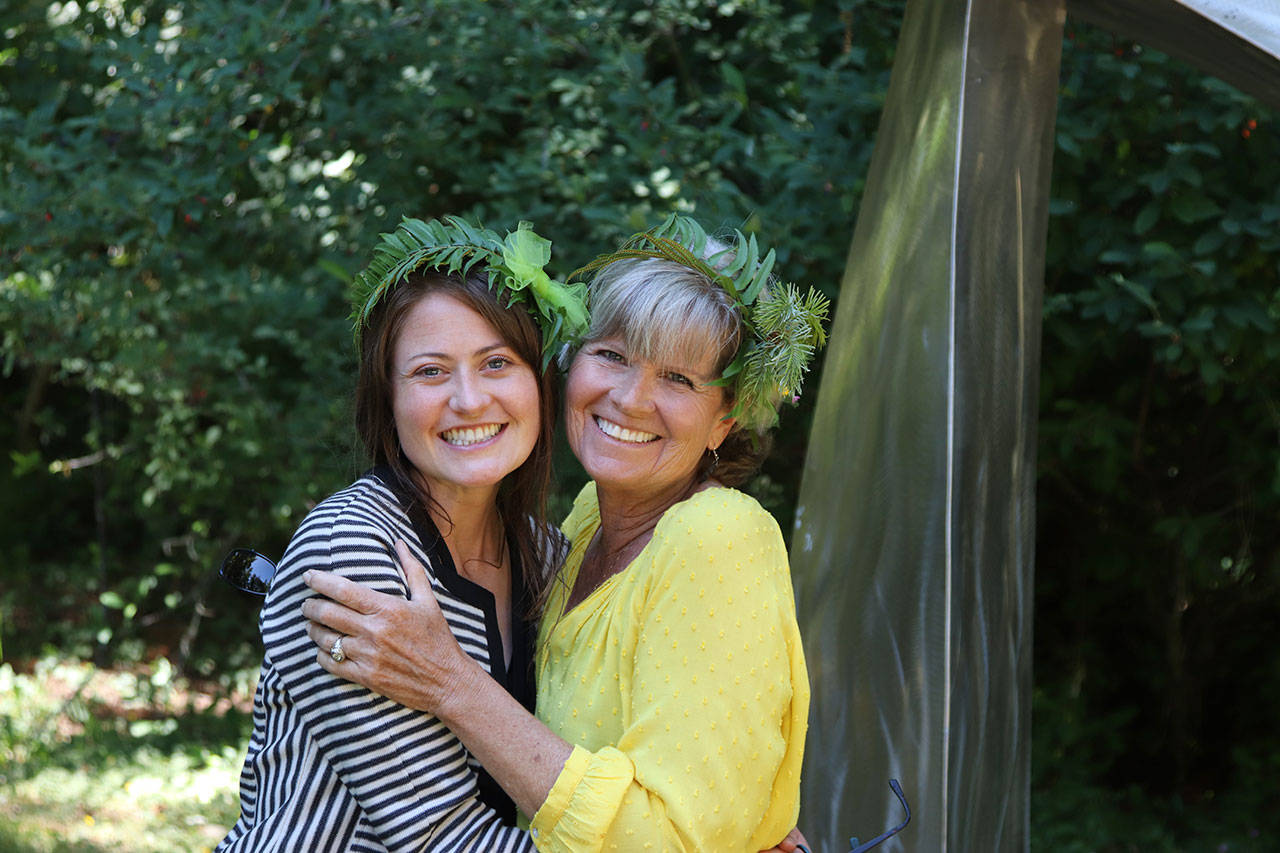 PAFAC Community Outreach Coordinator Lauren Bailey, left, and volunteer Wendy Cutting show off handmade Solstice Crowns at last years summer art festival. Photo by Sarah Jane