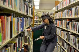 Mary Coté, customer service specialist in the Sequim Library, stocks shelves as part of her daily routine. North Olympic Library System officials say they have been working on reopening plans for weeks and look to offer some services, including curbside pickup of held materials and limited Outreach to the Homebound deliveries later this month. Sequim Gazette file photo by Matthew Nash
