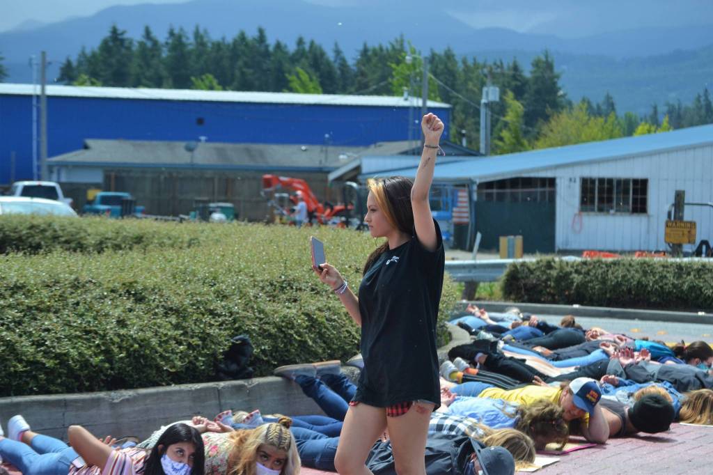 Nia Haley of Sequim videos demonstrators on June 4 at the circle the River Road roundabout in support of the Black Lives Matter movement. They laid on the ground for 8 minutes and 46 seconds to honor the memory of George Floyd and oppose police brutality. Sequim Gazette photo by Matthew Nash