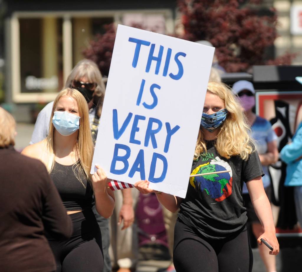 Joei Darminio, left, and Allie Van De Wege join protesters at Washington Street and Sequim Avenue. Sequim Gazette photo by Michael Dashiell