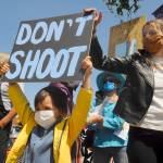 S. Beckett Thomas, 5, holds a Dont shoot sign with mom Courtney Thomas looking on. Courtney organized the protest, saying, Im scared for the world, for my son. This (protest) is the least I can do. Sequim Gazette photo by Michael Dashiell