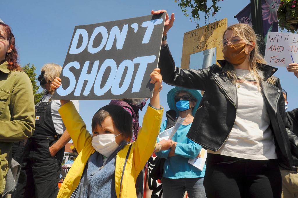 S. Beckett Thomas, 5, holds a Dont shoot sign with mom Courtney Thomas looking on. Courtney organized the protest, saying, Im scared for the world, for my son. This (protest) is the least I can do. Sequim Gazette photo by Michael Dashiell