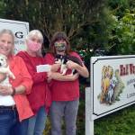 Real estate broker Karen Willcutt with Town & Country, on left, holds Zeke, a husky puppy, as she donates $1,000 from recent home sales to the Welfare for Animals Guild president Barbara Brabant and ranch manager Mel Marshall, holding Zuri the husky puppy. Sequim Gazette photo by Matthew Nash