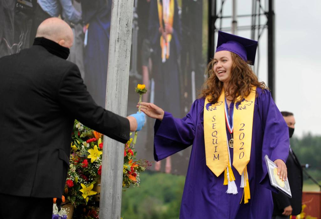 Graduating senior Vita Olson gets a flower from Sequim school superintendent Dr. Rob Clark at Fridays SHS commencement ceremony. Sequim Gazette photo by Michael Dashiell