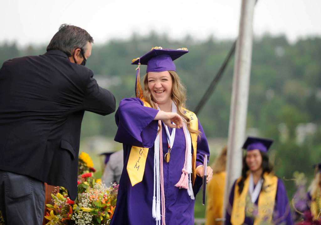 Payton Sturm gets an elbow bump from Sequim High School principal Shawn Langston at Fridays SHS commencement ceremony. Sequim Gazette photo by Michael Dashiell