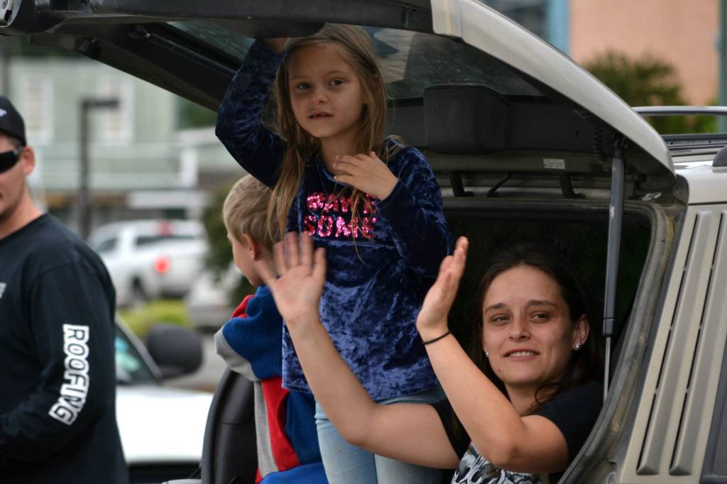 Sierra Hanning with her daughter Kassidy Burwash, 6, wave to graduates and their families as they drive on their way to graduation on June 19. The family members were there to support Sequim graduate Makenzie Campbell. Sequim Gazette photo by Matthew Nash