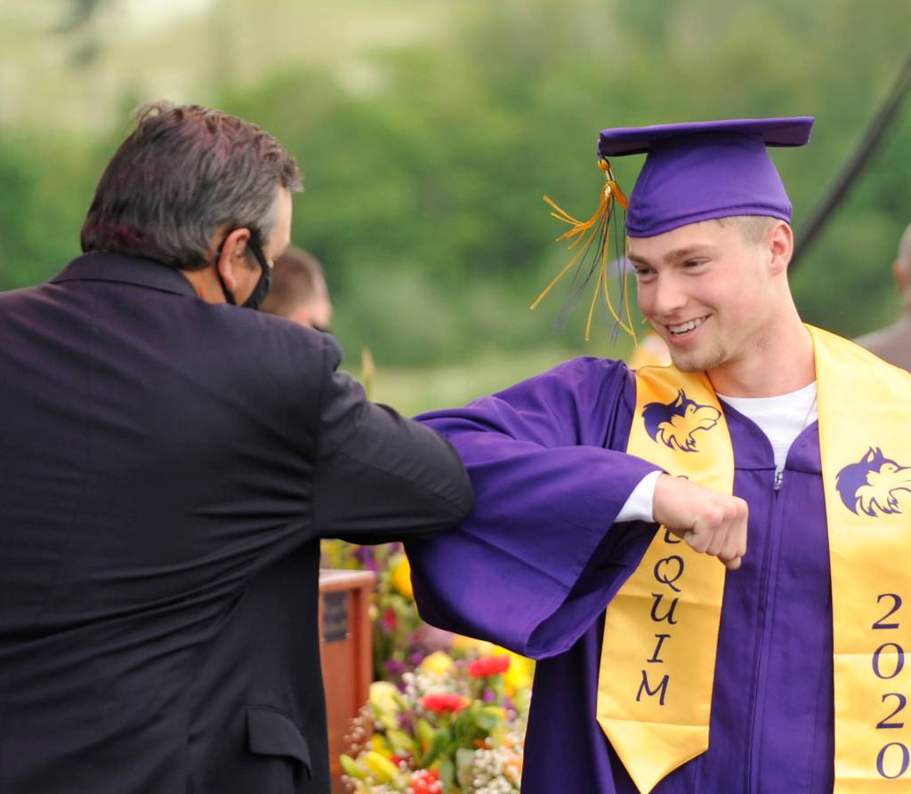 Jax Thaxton gets an elbow bump from Sequim High School principal Shawn Langston at Fridays SHS commencement ceremony. Sequim Gazette photo by Michael Dashiell
