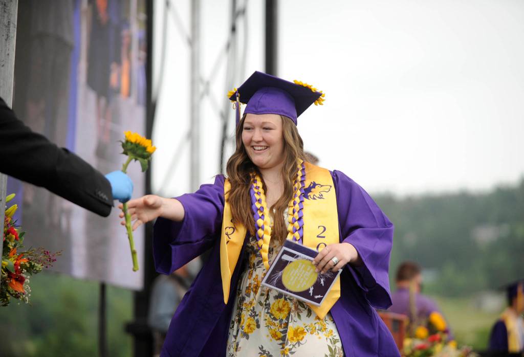 Graduating senior Alexis Smith gets a flower from Sequim school superintendent Dr. Rob Clark at Fridays SHS commencement ceremony. Sequim Gazette photo by Michael Dashiell