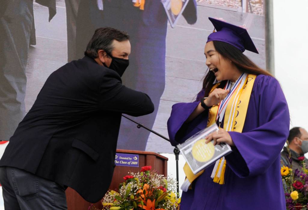 After receiving her diploma, class president Erin Dwyer gets an elbow bump from Sequim High School principal Shawn Langston at Fridays SHS commencement ceremony. Sequim Gazette photo by Michael Dashiell