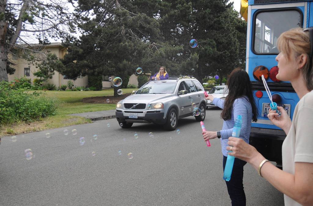 Kim Rosales, far right and Mary Budke blow bubbles for Lydia Stidham and other Sequim High seniors at Fridays graduation ceremony. Sequim Gazette photo by Michael Dashiell