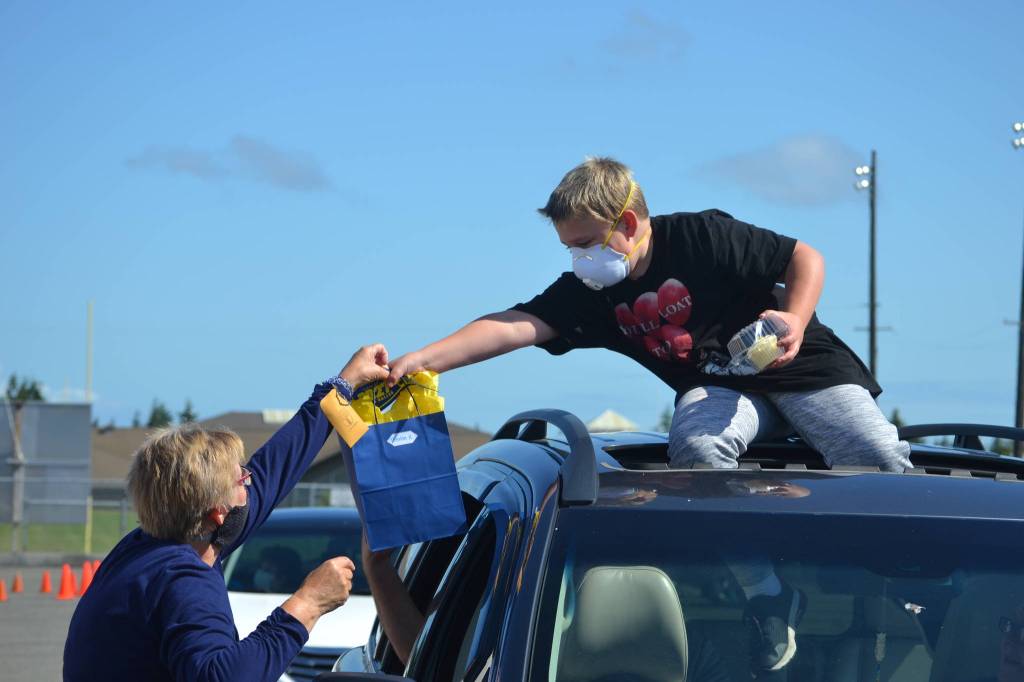 Outgoing fifth grader Trenton Hopson accepts a gift bag from his Helen Haller Elementary teacher Mary Himley on June 17 during a drive-thru graduation ceremony. Sequim Gazette photo by Matthew Nash