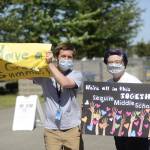 Sequim Middle School teachers Brad Meckley and Susan Dwyer cheer on graduating eight-graders at a drive-thru ceremony at the school on June 17. Sequim Gazette photo by Michael Dashiell