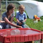 Teacher Lyberty Forville talks with 20-month-old William Sorensen about filling the water table at Sequims Little Explorers Early Learning Center. Sequim Gazette photo by Matthew Nash