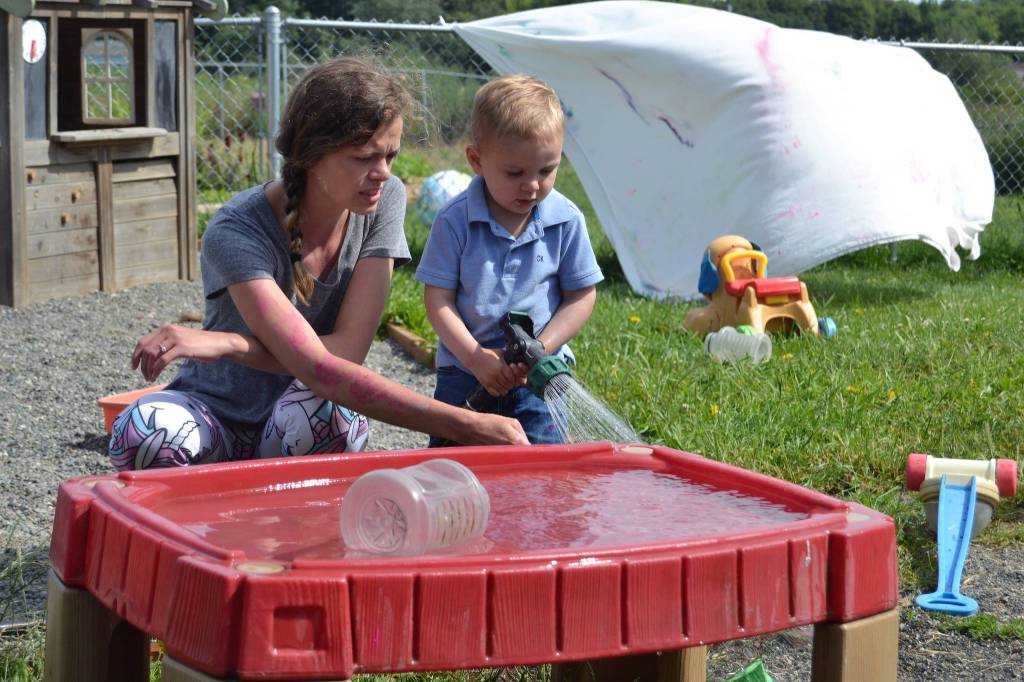Teacher Lyberty Forville talks with 20-month-old William Sorensen about filling the water table at Sequims Little Explorers Early Learning Center. Sequim Gazette photo by Matthew Nash