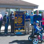 Members of the Rotary Club of Sequim (from left, Jason Bausher, Rochelle McHugh, Pat Zane and Jim Jones) join physical therapist Cherry Bibler in presenting a Rifton adaptive tricycle to 8-year-old Jorden Topham, pictured here with parents Chris Parizo and Anna Gloor, and brother Noah. Photo by Doug Schwarz