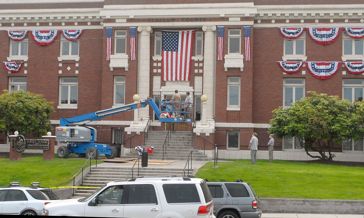 Clallam County Courthouse workers hang bunting on the front of the historic Port Angeles courthouse on Wednesday in honor of Independence Day. Photo by Keith Thorpe/Olympic Peninsula News Group