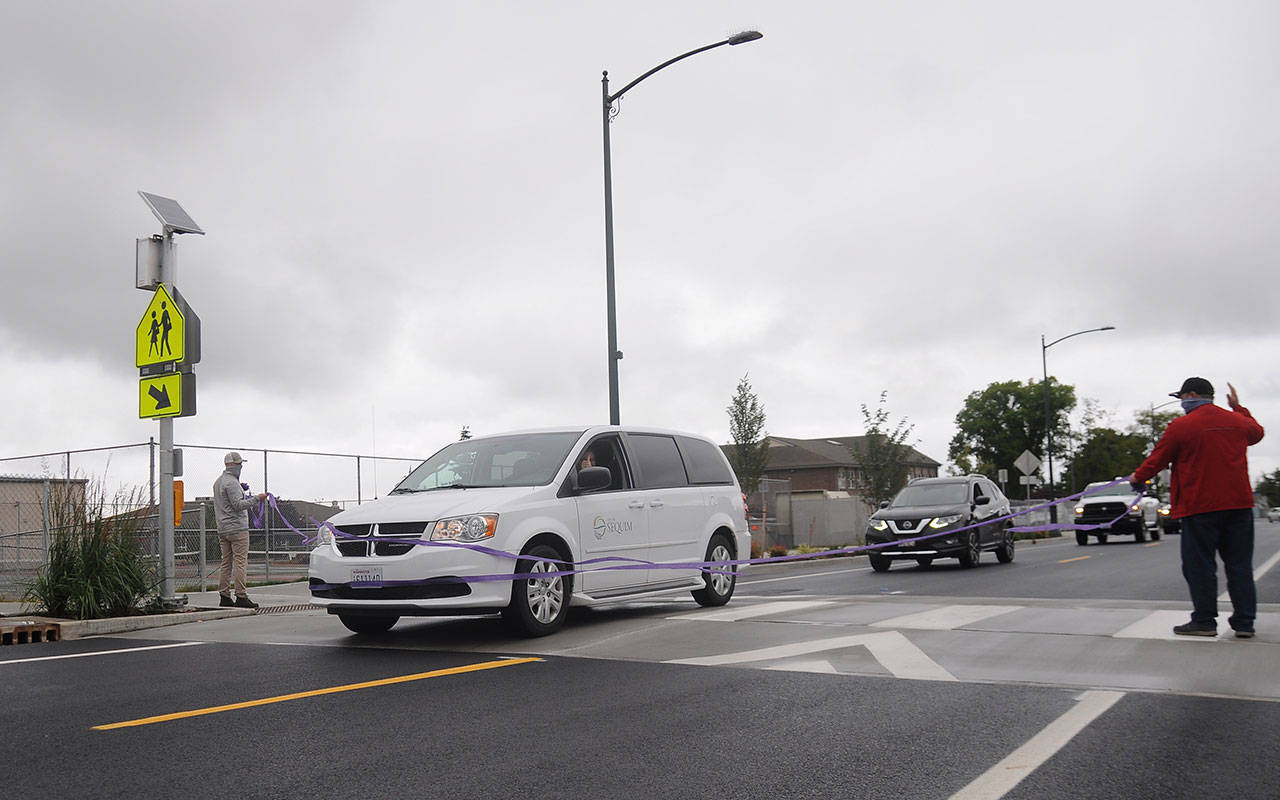Sequim Mayor Will Armacost cuts the ceremonial ribbon and leads a procession of City of Sequim Vehicles to fete completion the West Fir Street Rehabilitation Project on July 9. Sequim Gazette photo by Michael Dashiell