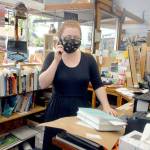 Helena Poho, a clerk at Port Book and News in Port Angeles, talks with a customer by phone last week at the Port Angeles bookstore. Photo by Keith Thorpe/Olympic Peninsula News Group