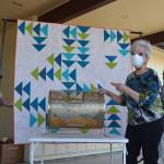 Sue Nylander draws Jess Ruby of Sequim as the winner of the Sunbonnet Sue Quilt Clubs annual quilt raffle, as Sharon Clayton, club president, on left, and Barbara Davis hold the quilt outside the Sequim Masonic Lodge on July 19. Sequim Gazette photo by Matthew Nash