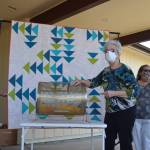 Sue Nylander draws Jess Ruby of Sequim as the winner of the Sunbonnet Sue Quilt Clubs annual quilt raffle, as Sharon Clayton, club president, on left, and Barbara Davis hold the quilt outside the Sequim Masonic Lodge on July 19. Sequim Gazette photo by Matthew Nash