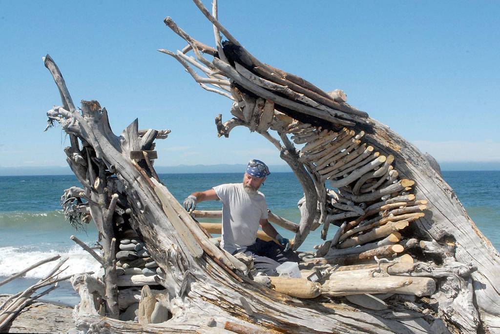 Sky Darwin of Port Angeles works on Saturday, July 18, to reconstruct the heart sculpture that was burned last spring on Ediz Hook along the Strait of Juan de Fuca. Photo by Keith Thorpe/Olympic Peninsula News Group