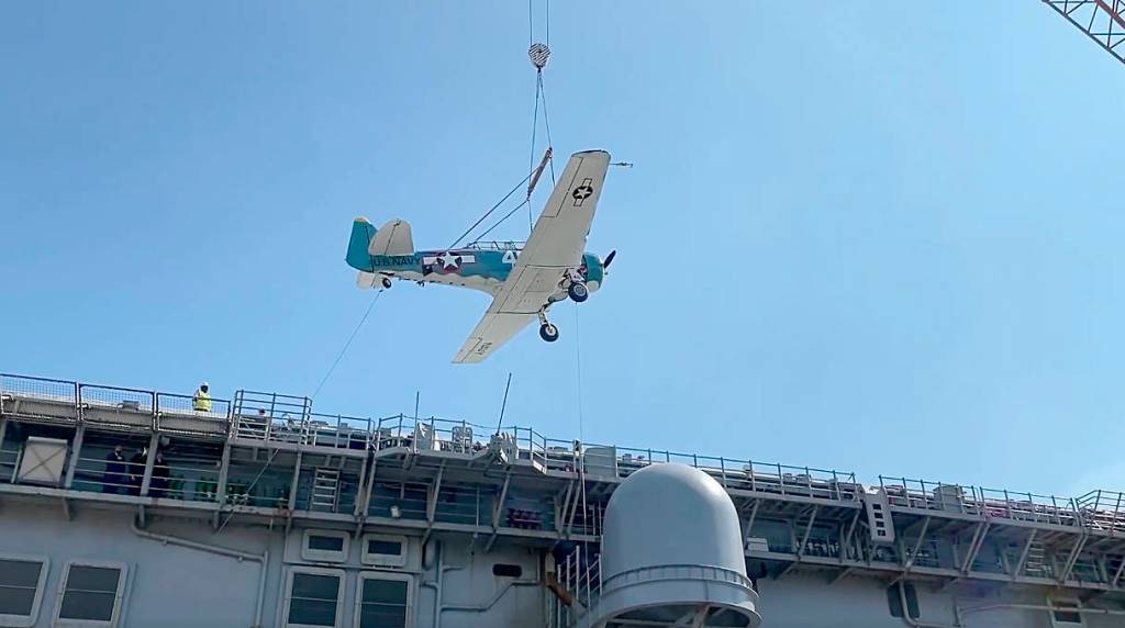John Johnsons T-6 airplane is loaded on July 25 aboard the USS Essex for its journey to Pearl Harbor for the 75th commemoration of the end of War War II in the Pacific Ocean in late August. Photo courtesy of Dave Richardson