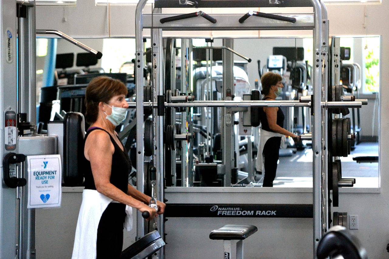 Connie Kinyon of Sequim works out for the first time in the Sequim YMCA on Tuesday morning after it reopened the day before to the public after months closed due to safety regulations for COVID-19. Im happy to be back, Kinyon said. I feel very safe in here as for them being open. Sequim Gazette photo by Matthew Nash