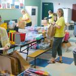 Janet Gray (third from right) and volunteers fill bags with school supplies for students at the 2019 Sequim Back To School Fair. This years fair is set for Aug. 29. With a number of health restrictions in place, organizers have changed the event to a drive through model. Sequim Gazette file photo by Conor Dowley