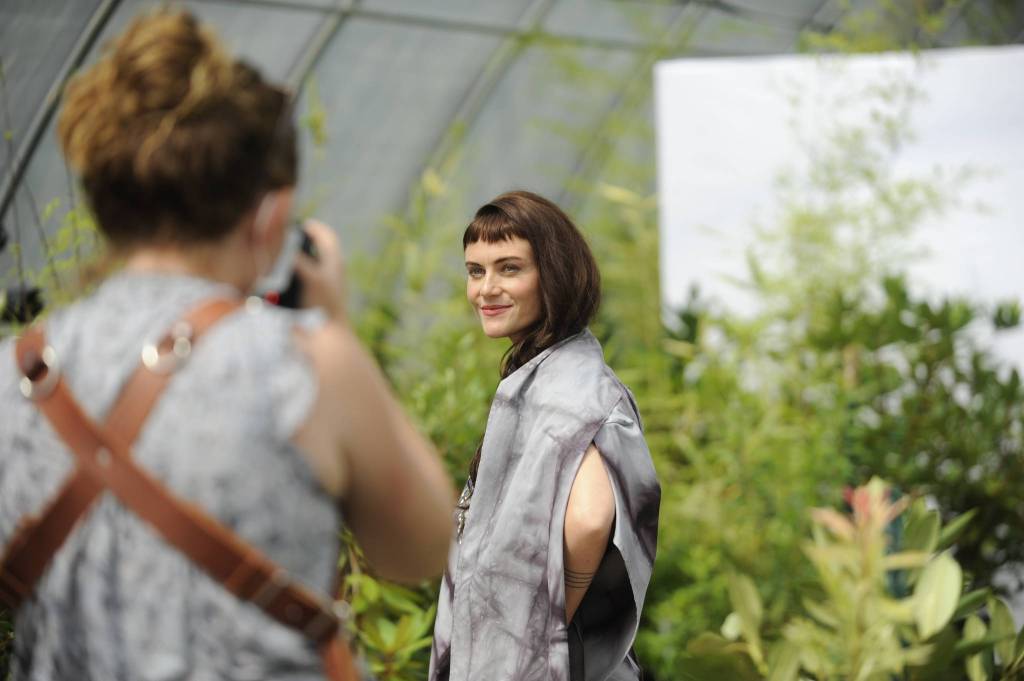 Photographer Cindy Roth snaps shots of Sequim model Aurora Lagattuta for impact Fashions sustainable fashion show on Aug. 6 inside a greenhouse at New Dungeness Nursery. Sequim Gazette photo by Matthew Nash