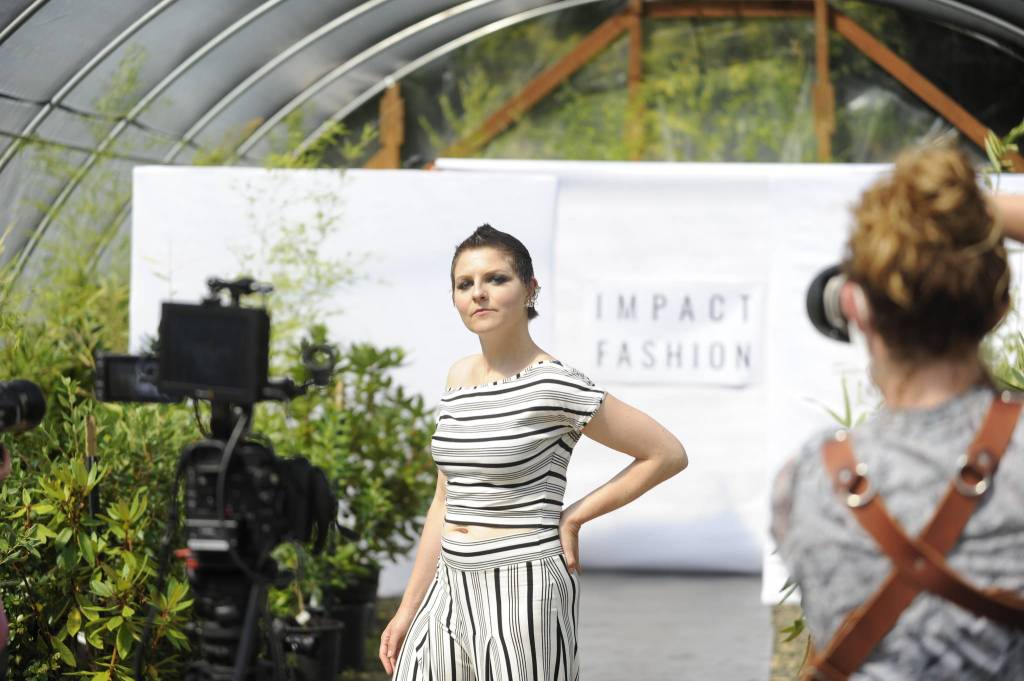 Sarah Shea of Sequim walks the runway to promote sustainable clothing lines through Impact Fashion. Photographers and videographers like Cindy Roth, right, will help compile footage and photos for the Sept. 4 debut of the fashion show as part of a two-day summit.