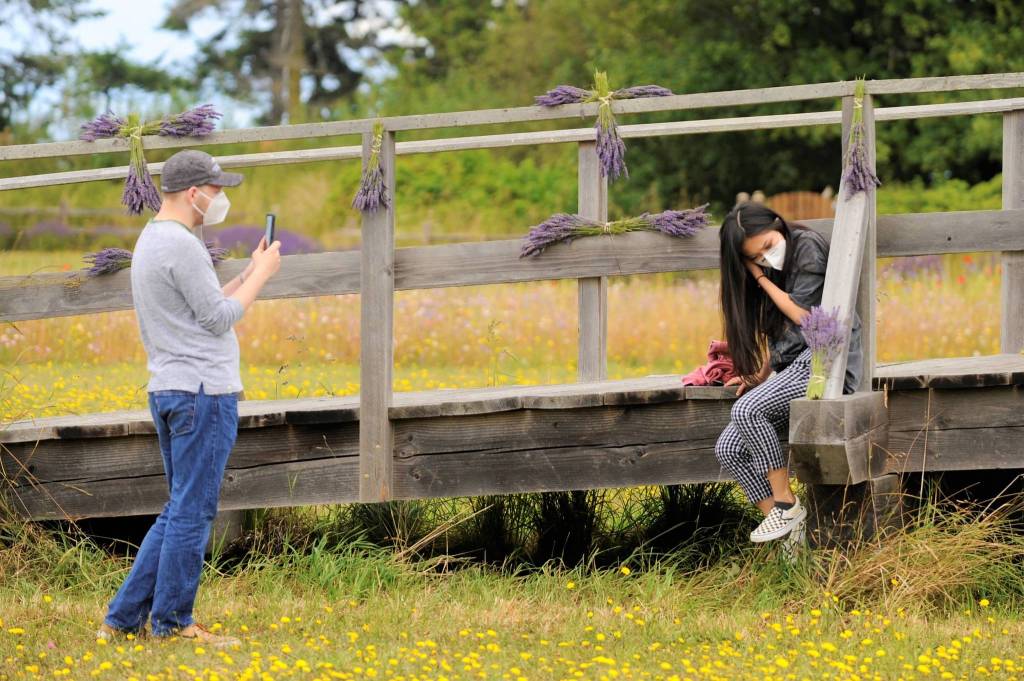 Scott Cameron takes a photo of Aimee Wu on the bridge at George Washington Inn on Aug. 8 during an adapted Northwest Colonial Festival. In past years, organizers held reenactments of the Battle of Concord Bridge, but due to COVID-19, organizers adapted the event to an encampment with living history examples. Sequim Gazette photo by Matthew Nash