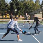 With doubles teammate Sue Haus (back, left) looking on, John Herbold lines up a shot as the pair take on Laurie McColl and Al Harris in pickleball play at Carrie Blake Community Park on Aug. 14. Sequim Gazette photo by Michael Dashiell