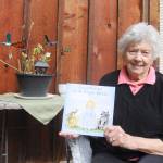 Sequim author JoAnn Fisher displays her first book, Adventures with Angel Betsy. Illustrations (at left) are by Ukranian artist Irina Litvin. Sequim Gazette photo by Michael Dashiell