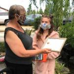 Ten-year-old Chloe Dunn of Port Angeles won an Amazon Fire tablet from the Clallam County Literacy Council for winning in her age bracket in the groups writing contest. Here the groups chairperson Philomena Lund presents a certificate and tablet to Dunn. Submitted photos