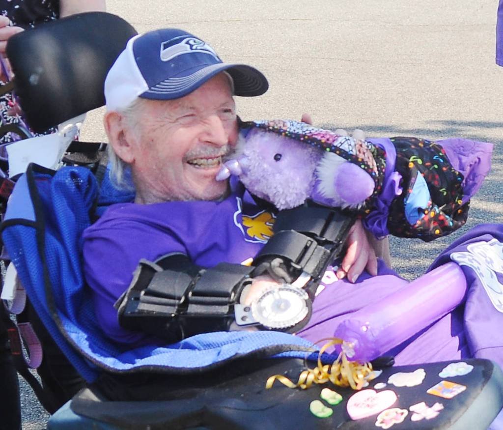 Myron Teterud, a longtime Sequim High sports fan, enjoys some gifts from Sequim Alumni Association members and friends on Sept. 8. Sequim Gazette photo by Michael Dashiell