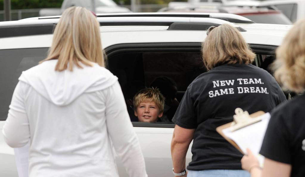 Second-grader Braylon Waters talks with teacher Gretta Rich, left, and Greywolf principal Donna Hudson at the schools packet pick-up on Sept. 2, the first day of school for Sequim students. Sequim Gazette photo by Michael Dashiell
