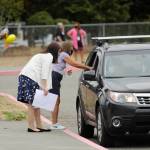 First-grade teachers Gwen Rudzinski, left, and Monique Brasher greet parents and students on Sept. 2, the first day of school for Sequim students, at Greywolf Elementary in Carlsborg. With studentsstarting the academic year learning remotely, teachers and staff handed out instructional materials at the campus. Sequim Gazette photo by Michael Dashiell