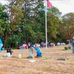 Members of the Michael Trebert Chapter of the Daughters of the American Revolution and Sequim Sunrise Rotary groups tend to headstones and plaques of veterans at Sequim View Cemetery last week. Photo by Bob Lampert