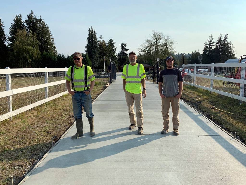 Brothers Daniel, left, and Sam, right, stand with their dad Rex Berneking at a concrete project they worked on together. Over the years, Rex has employed all of his sons for his Berneking Concrete Homes. Submitted photo