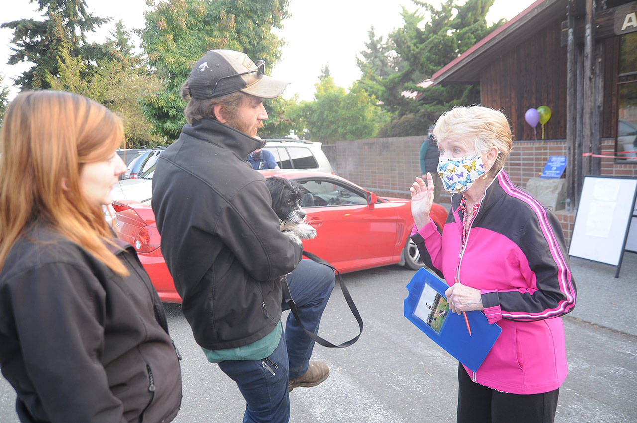At right, Sharon Palmer, who coordinated a spay/neuter clinic for Peninsula Friends of Animals, helps a couple with their four dogs gets services at Sequim Animal Hospital on Sept. 30. Sequim Gazette photo by Michael Dashiell