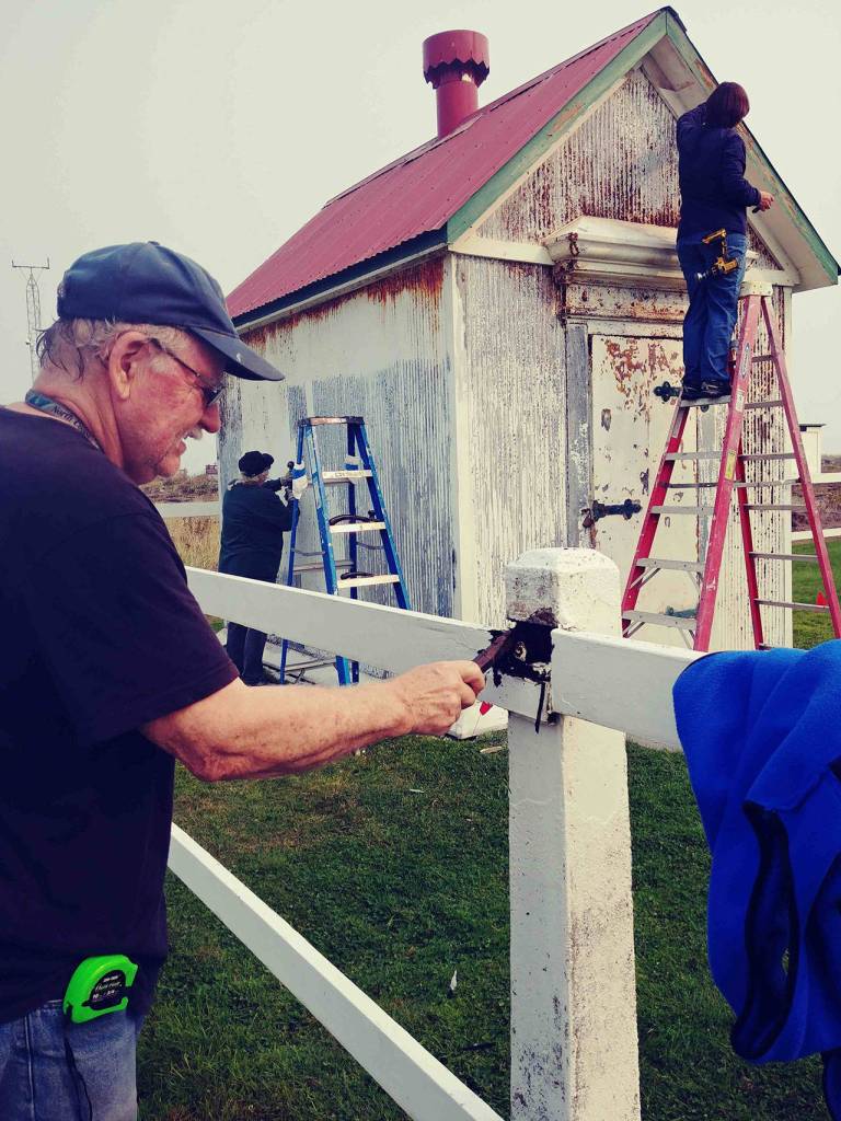 From left, volunteer work crew members Bill Bjorklund, Melody Monson and Sarah Miller add some new paint at the New Dungeness Lighthouse this summer. Photo Julie Bacher