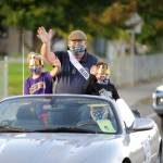 Grand Marshal Phil Castell, joined by grandsons Grayson Castell, left and Bennett Castell, waves to a virtual crowd and a few onlookers along Sequim-Dungeness Way during the Sequim Irrigation Festivals makeshift Grand Parade/Procession on Saturday, Oct. 10. John Coulson is pictured driving his classic Jaguar XK8. Sequim Gazette photo by Michael Dashiell