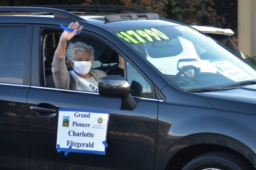 Grand Pioneer Charlotte Fitzgerald waves as she rides along Washington Street on Oct. 10 during the Sequim Irrigation Festivals procession. Sequim Gazette photo by Matthew Nash