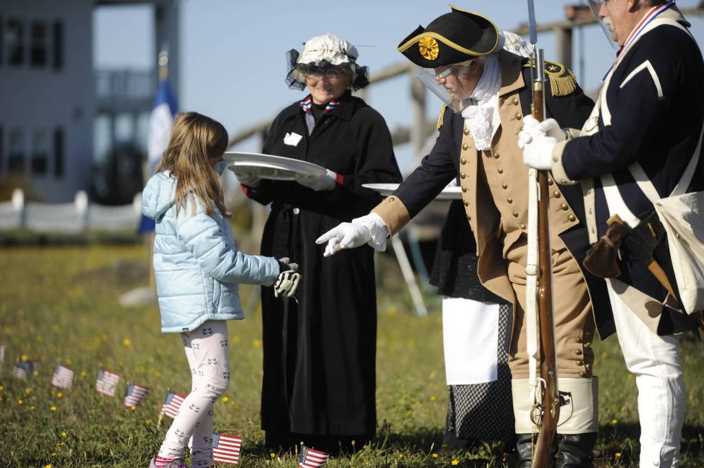George Washington (Vern Frykholm of Sequim) hands a special medal to Ameila Jusko, 7, of Port Angeles, at a special veterans event at George Washington Inn on Oct. 24. Sequim Gazette photo by Michael Dashiell